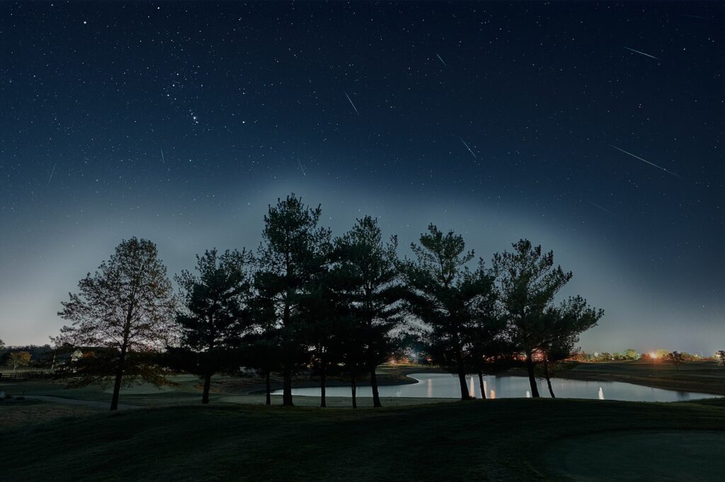 Smugi meteorów na rozgwieżdżonym nocnym niebie